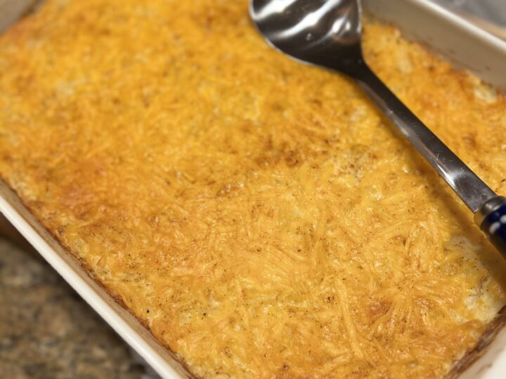 A easy cheesy hashbrown casserole baked in a 13x9 white dish.