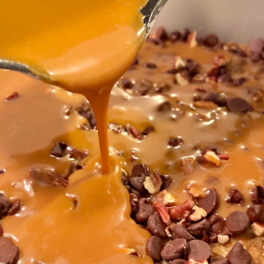 pouring melted caramel for the carmelita cookie bar recipe